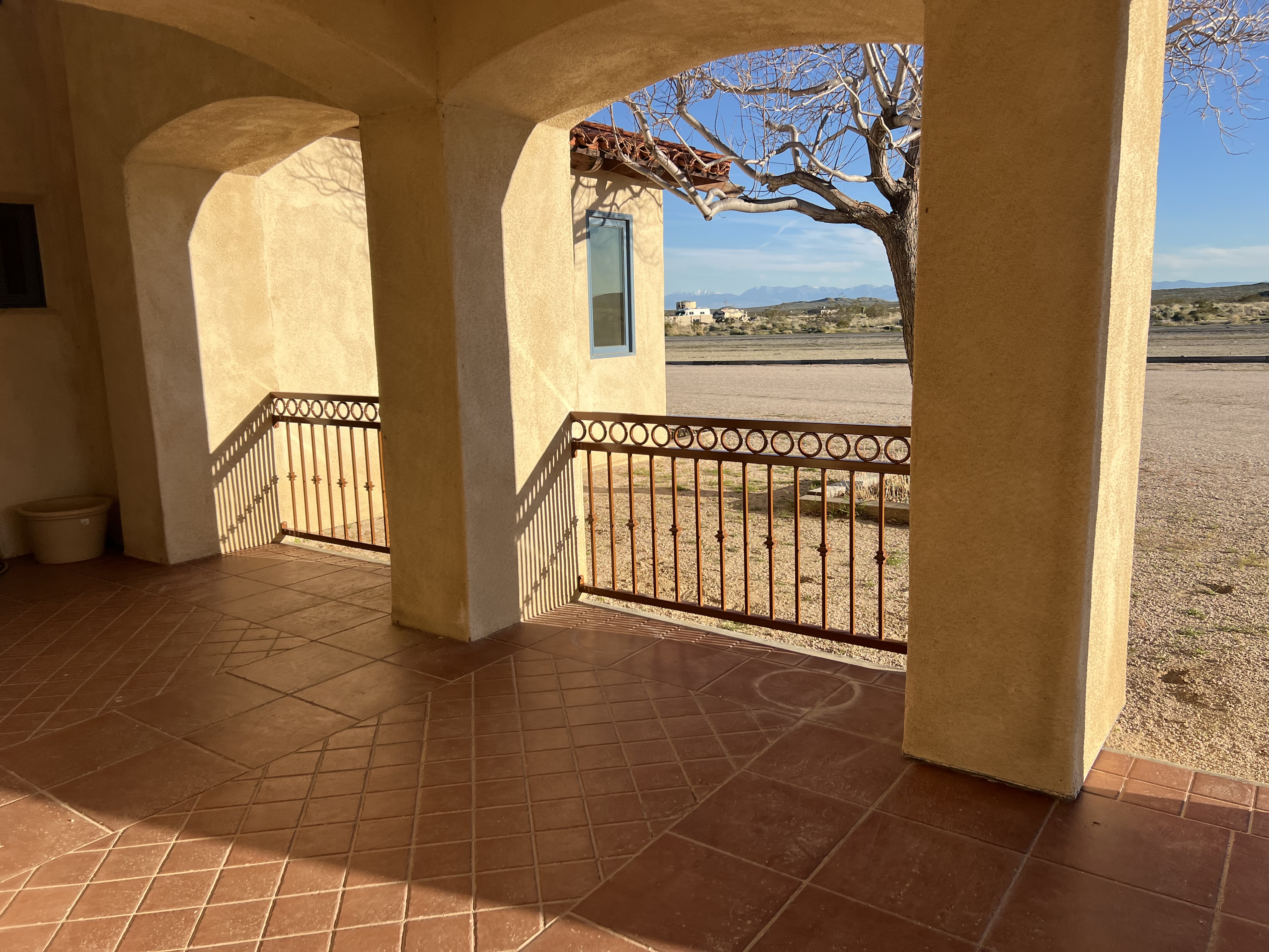 Ornamental iron patio railing — view through arched columns