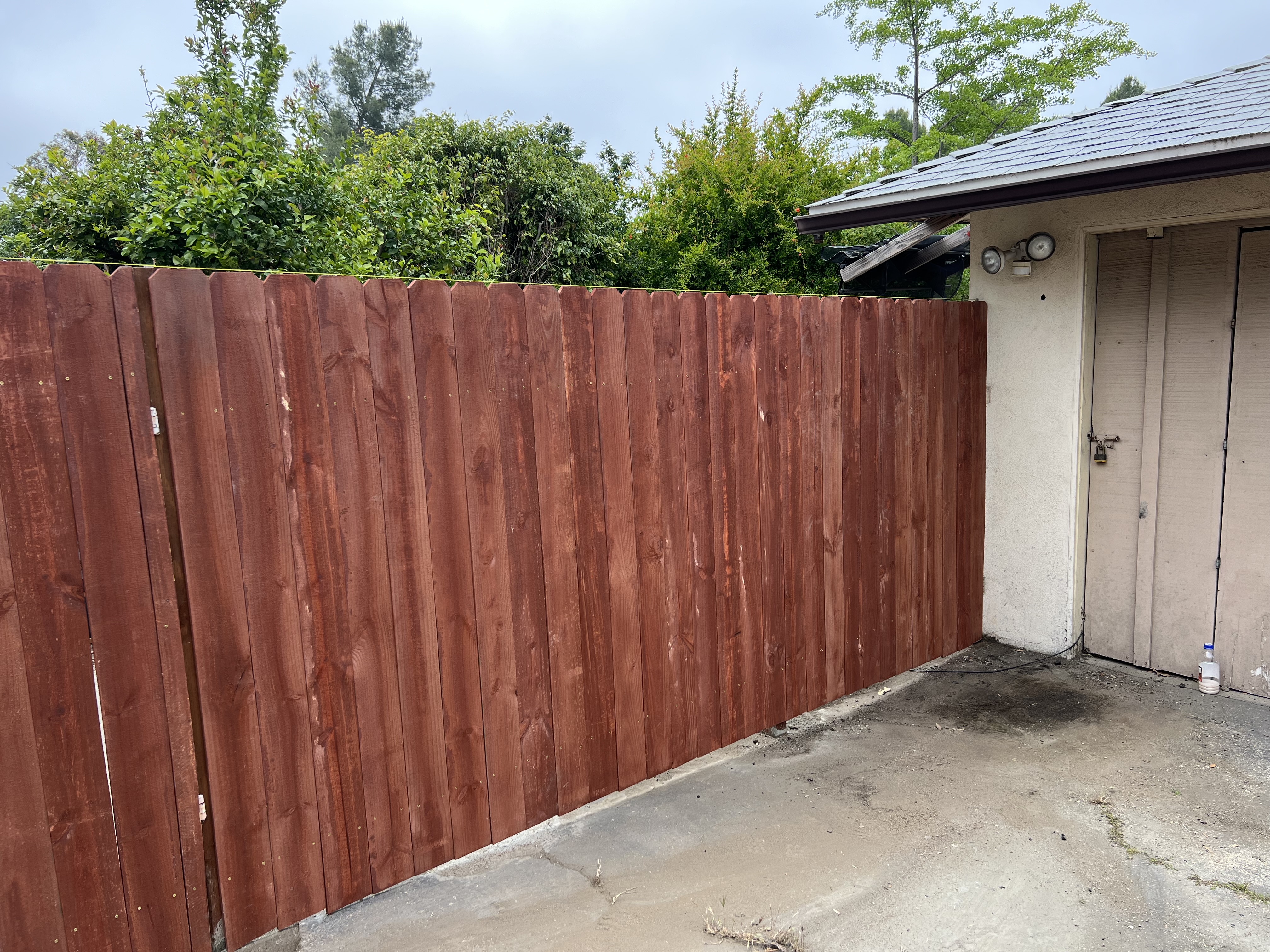 Stained cedar privacy fence dark red-brown