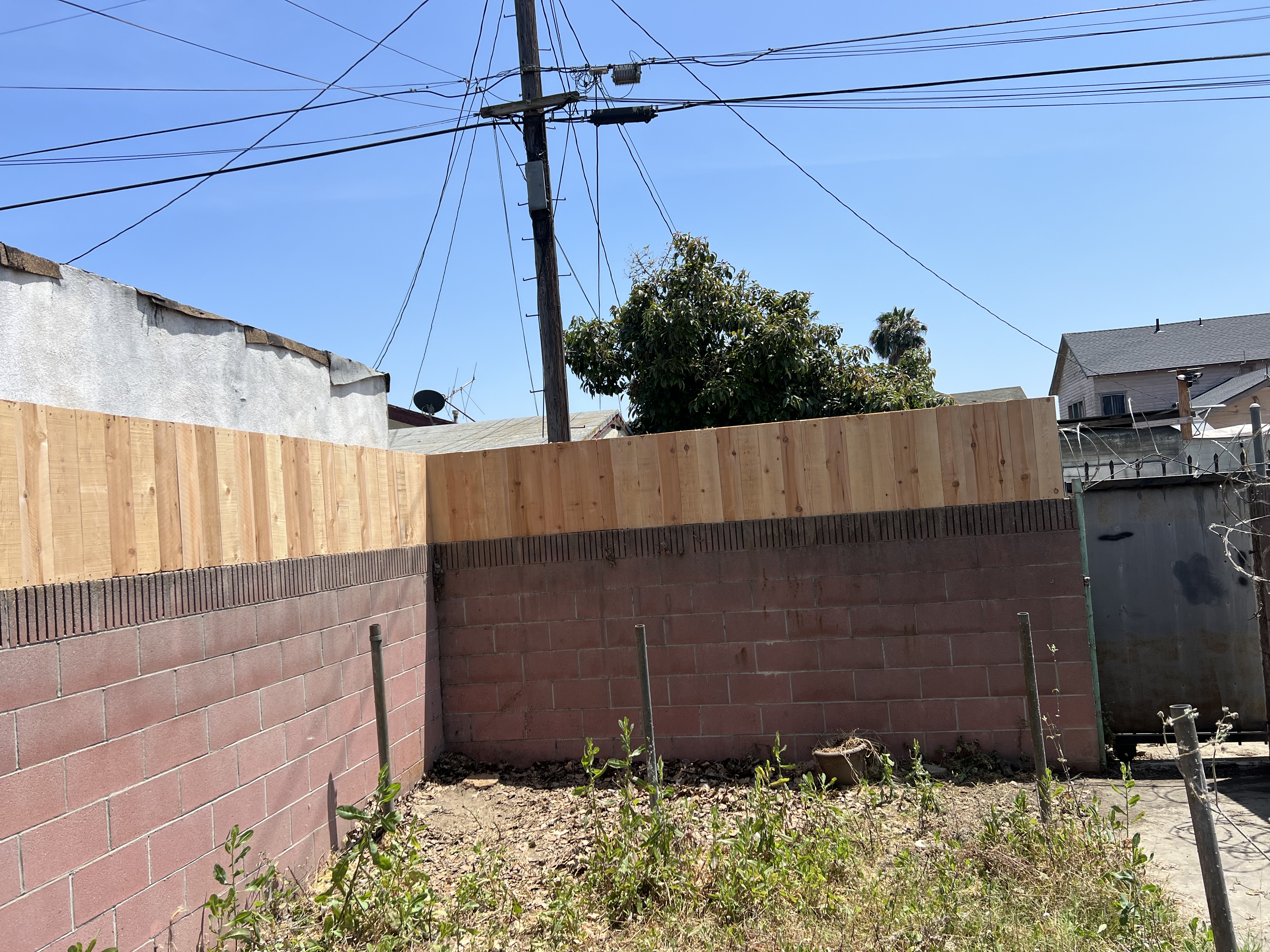 Natural cedar wood fence extension on top of existing block wall — urban residential